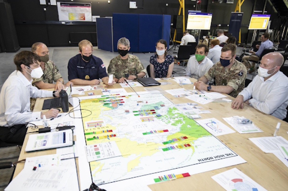 Military and civilian participants collaborating on wargame