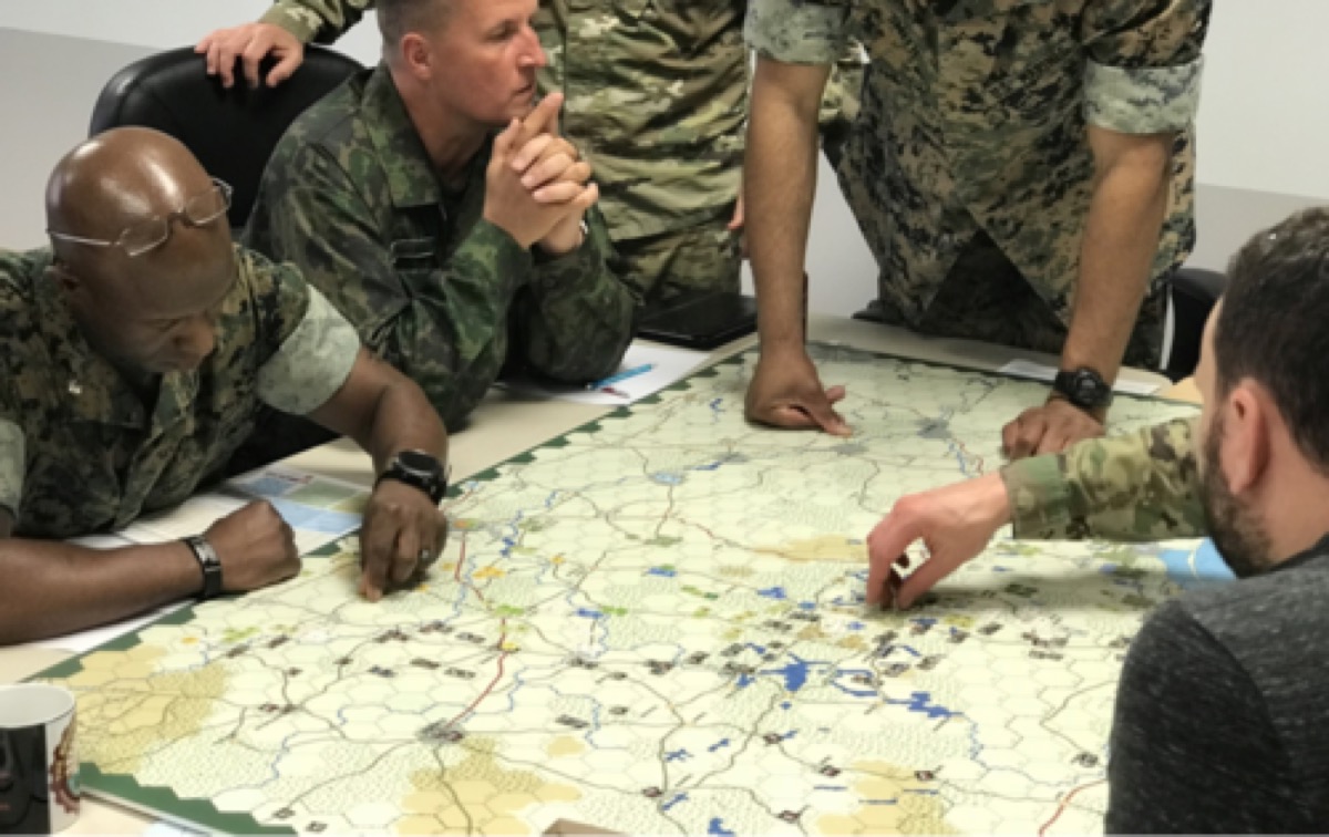 Military strategists analyzing wargame map